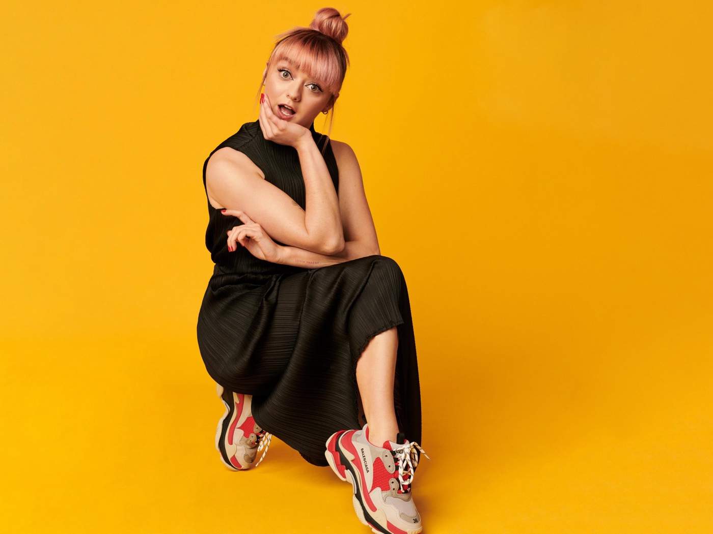 Актриса Мэйси Уильямс в черном платье на желтом фоне