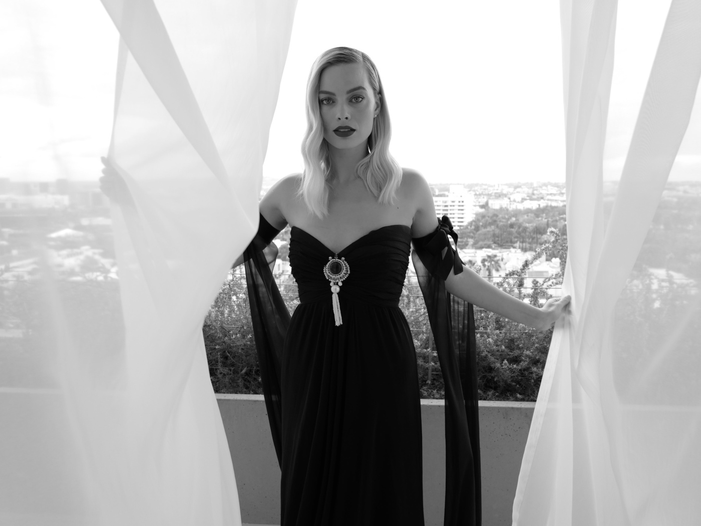 Актриса Марго Робби в черном платье на балконе 