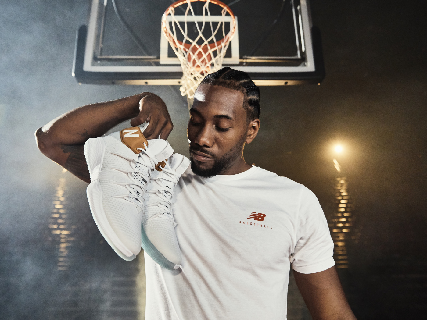 Американский баскетболист Кавай Леонард с кроссовками в руке
