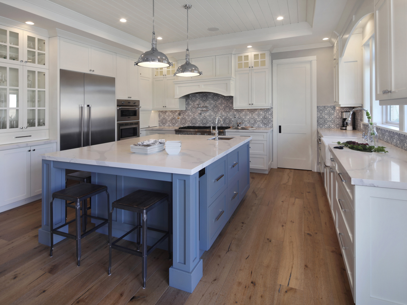 Большой серый стол в просторной белой кухне 