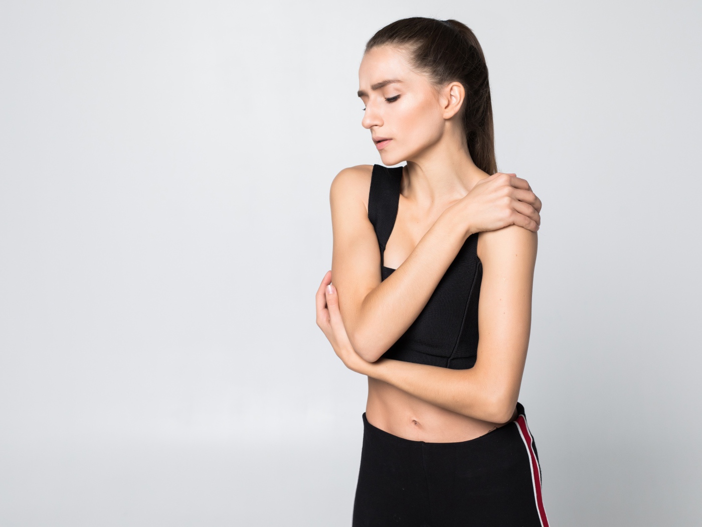 Скромная спортивная девушка на сером фоне