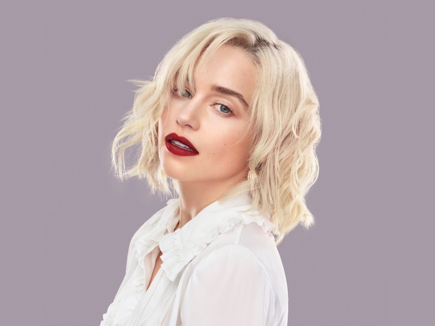 Эффектная блондинка, актриса Эмилия Кларк на сером фоне