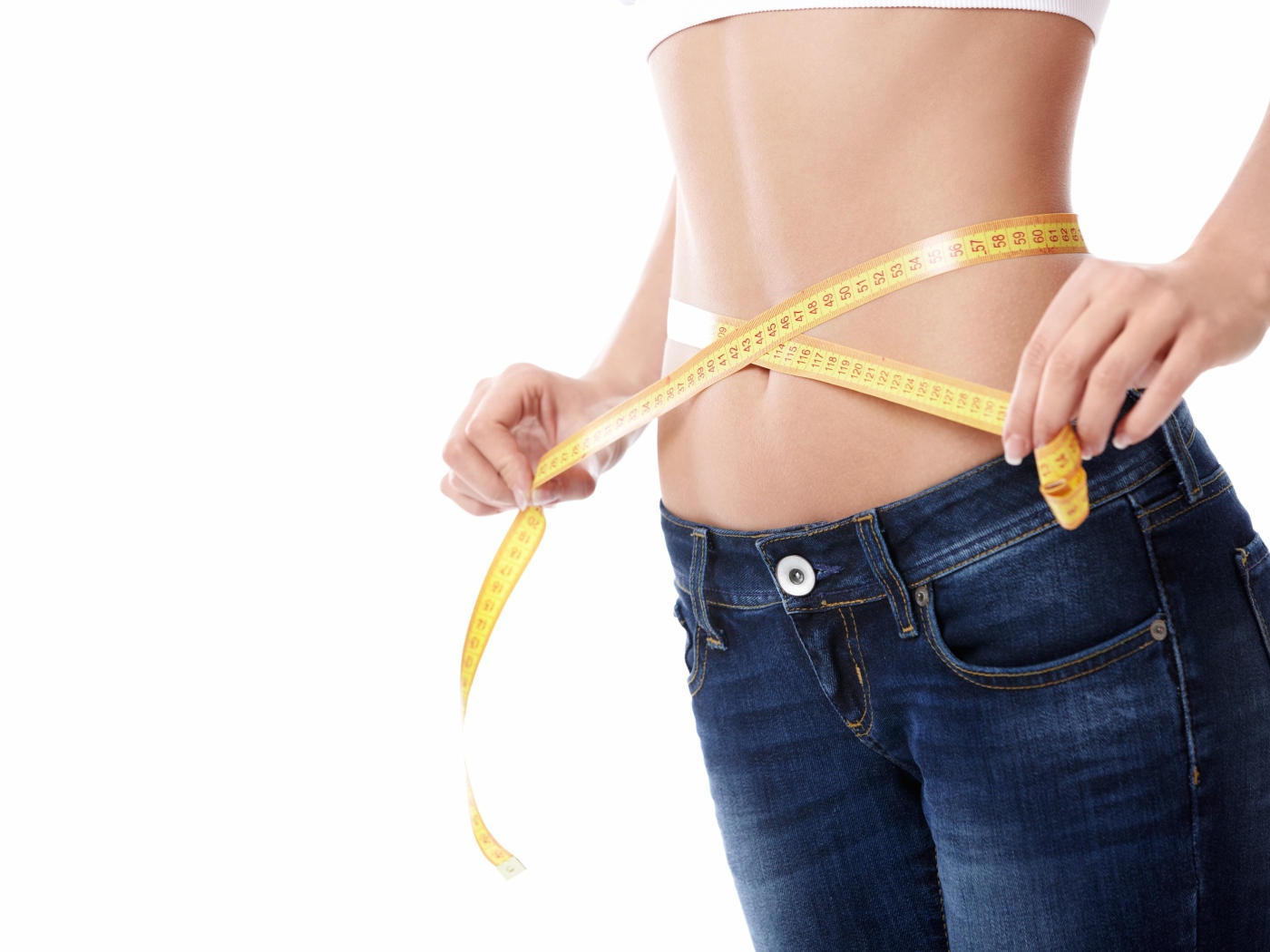 Стройная девушка меряет талию сантиметром 