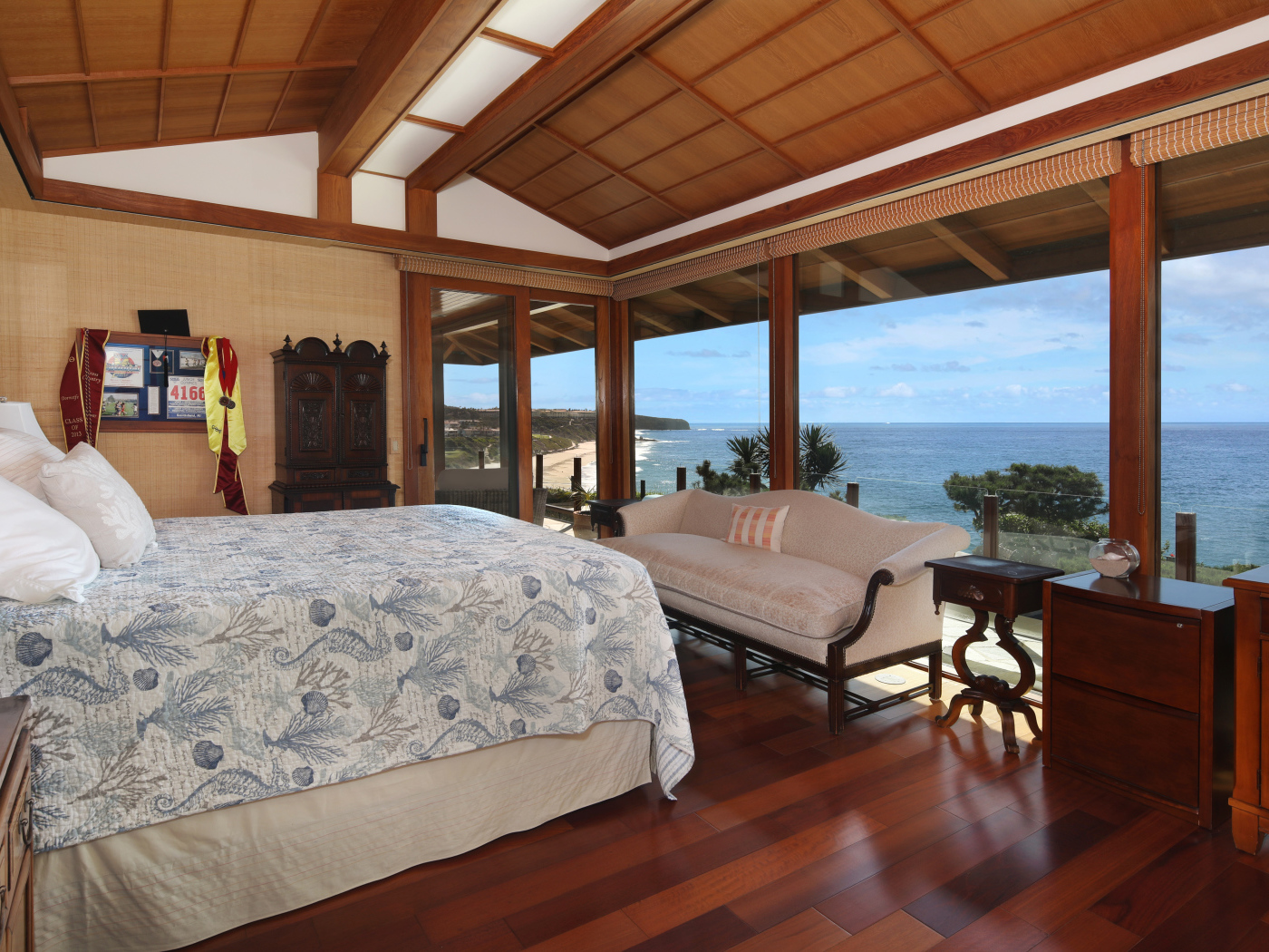Wooden bedroom with a large bed and sea view