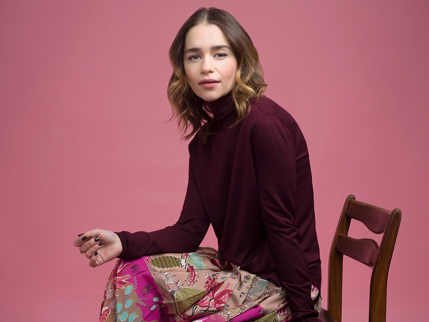 Молодая актриса Эмилия Кларк сидит на стуле