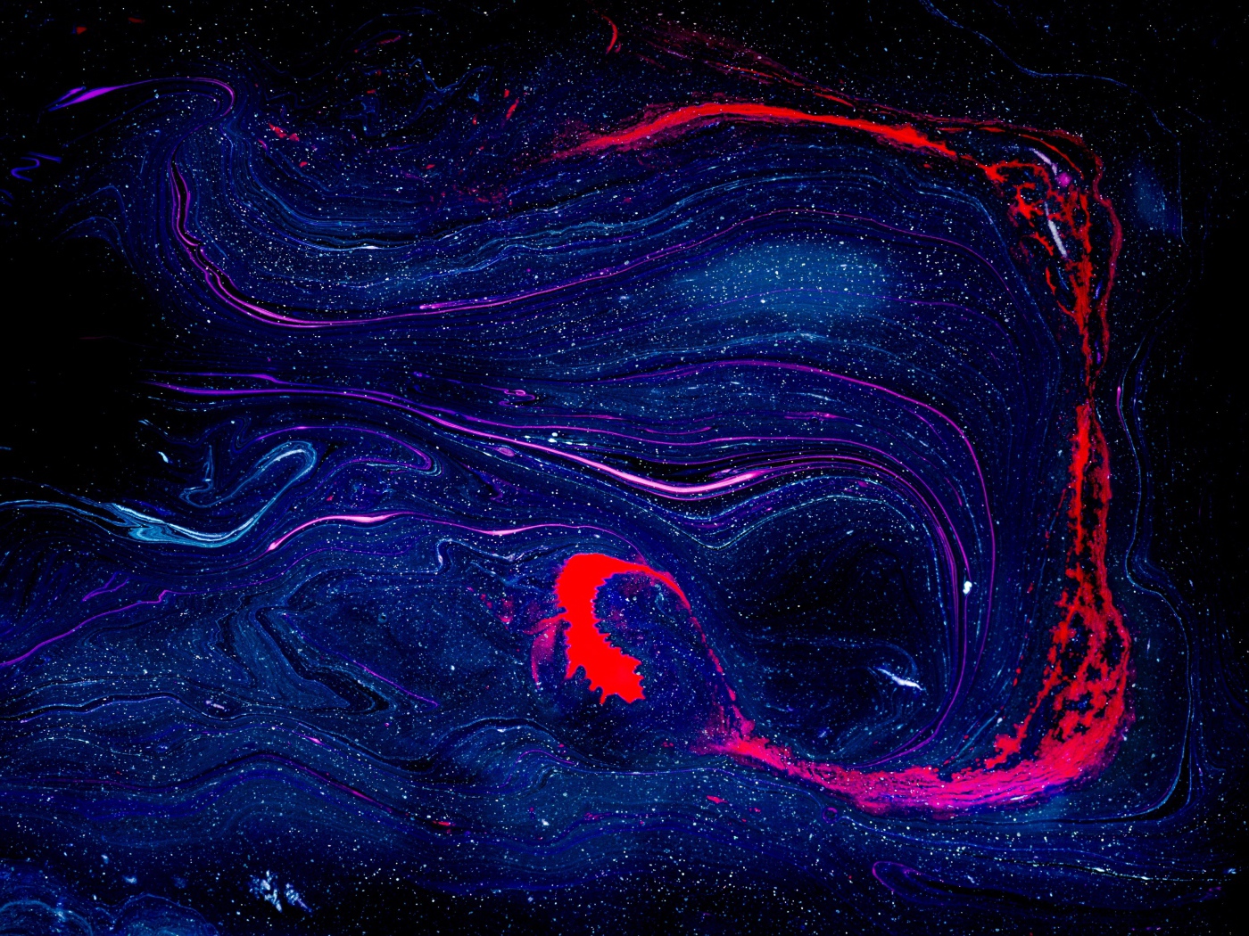 Blurry smudge of blue and red paint on black background