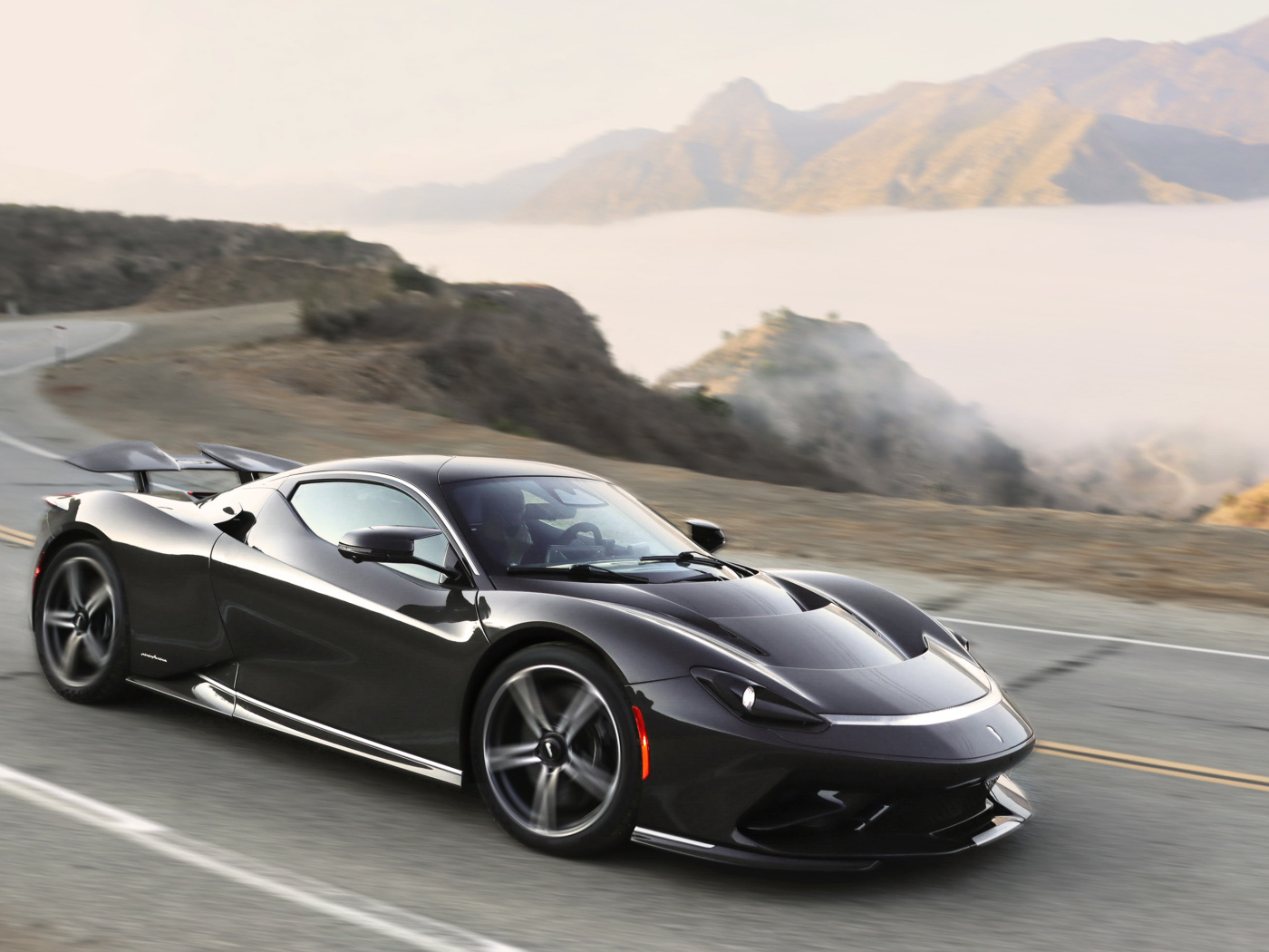 Черный спортивный автомобиль Pininfarina Battista,  2022 года на трассе