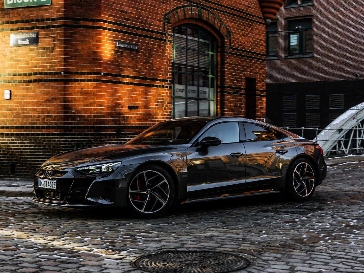 Черный автомобиль Audi RS E-Tron GT 2021 года у здания