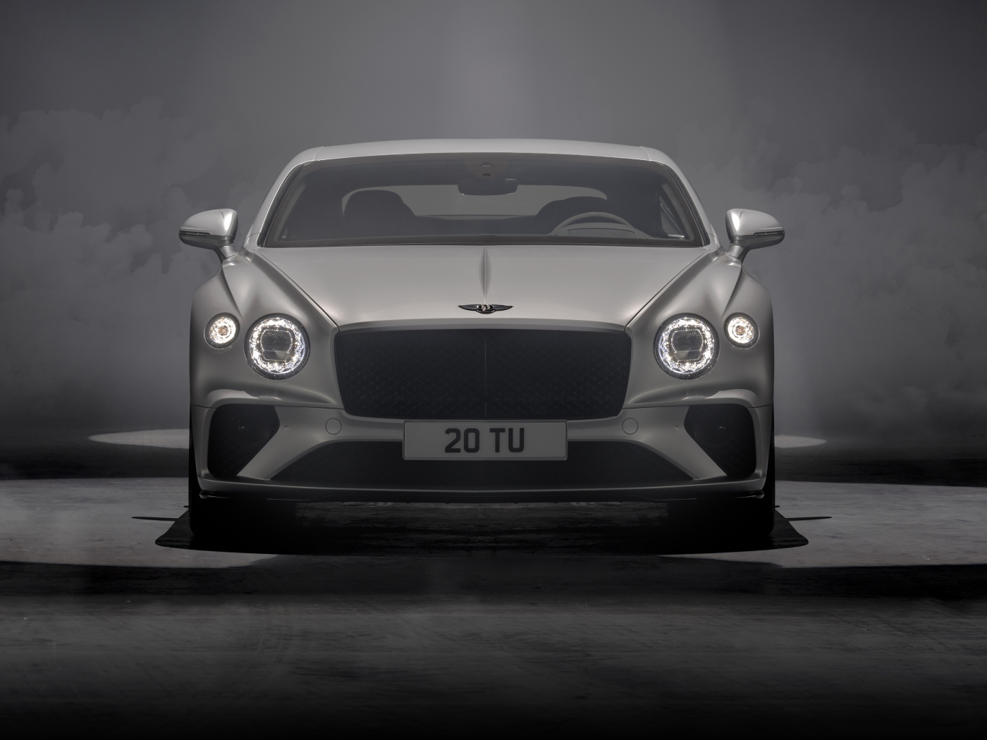 Серебристый автомобиль Bentley Continental GT Speed 2021 года на сером фоне