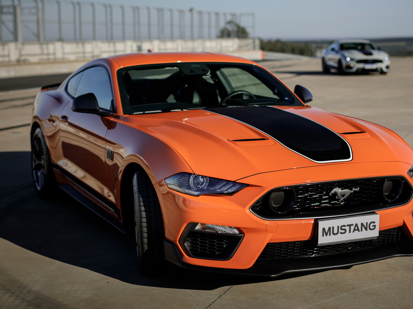 Оранжевый автомобиль Ford Mustang Mach 1 2021 года