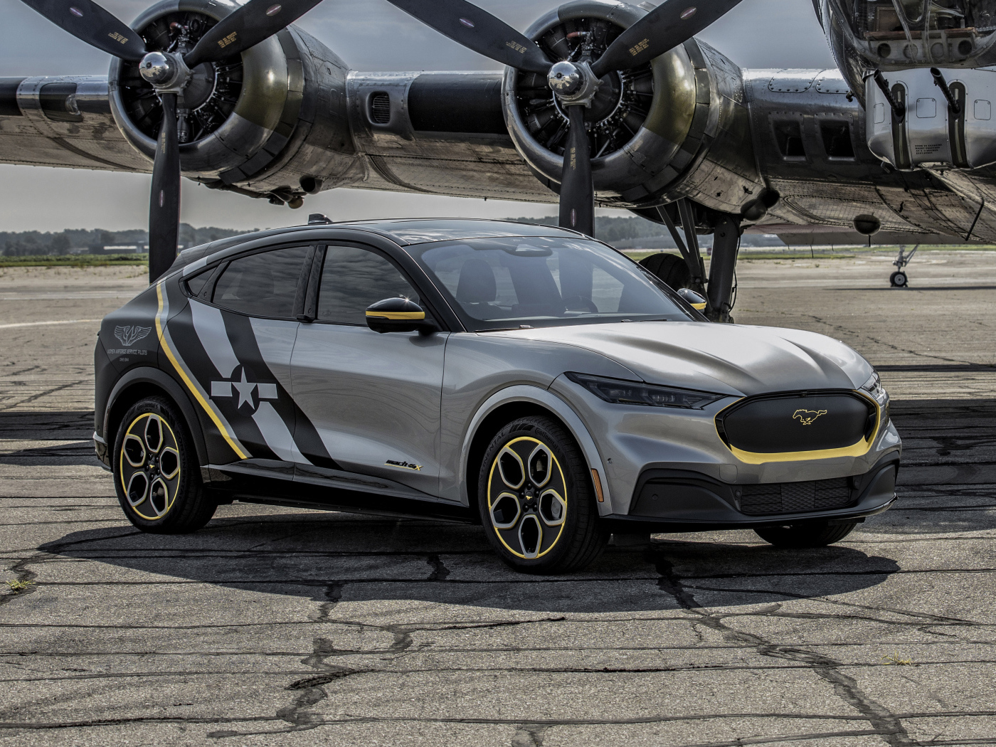 Серебристый Ford Mustang Mach-E, 2021 года у самолета