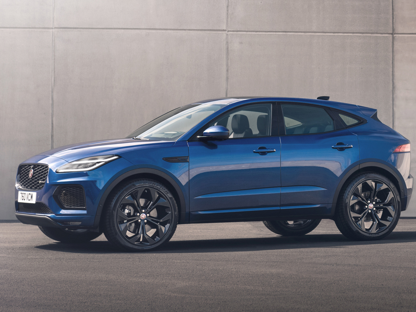 Синий Jaguar E-Pace R-Dynamic Black Pack 2021 года на фоне стены