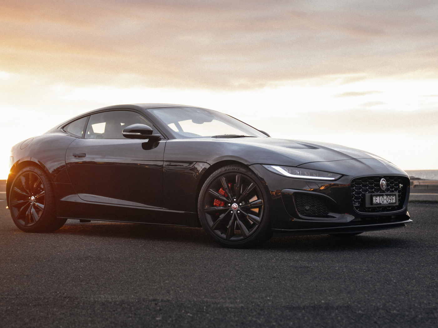 Черный автомобиль Jaguar F-Type R Coupé в лучах солнца