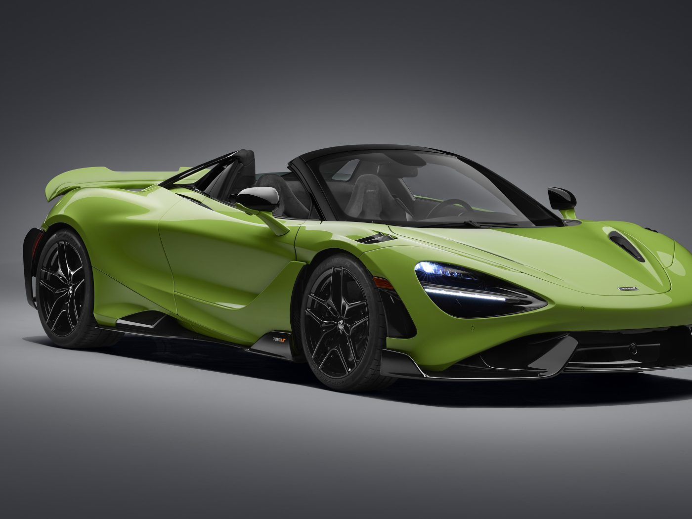 Зеленый автомобиль McLaren 765LT Spider 2022 года на сером фоне