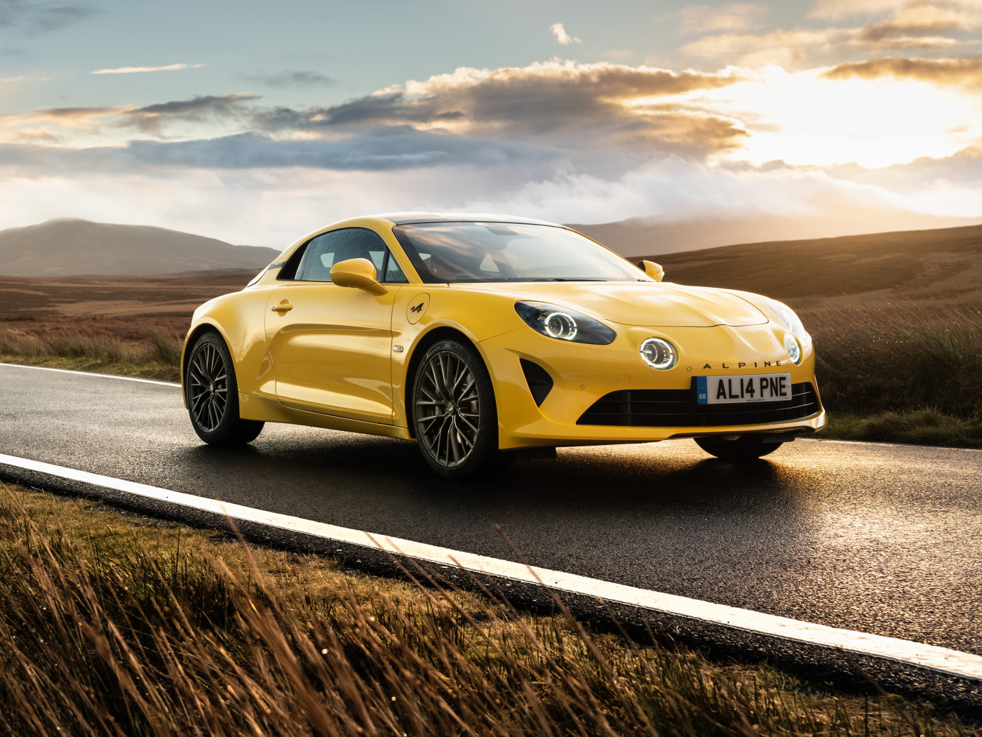Желтый автомобиль Alpine A110, 2021 года на фоне заката