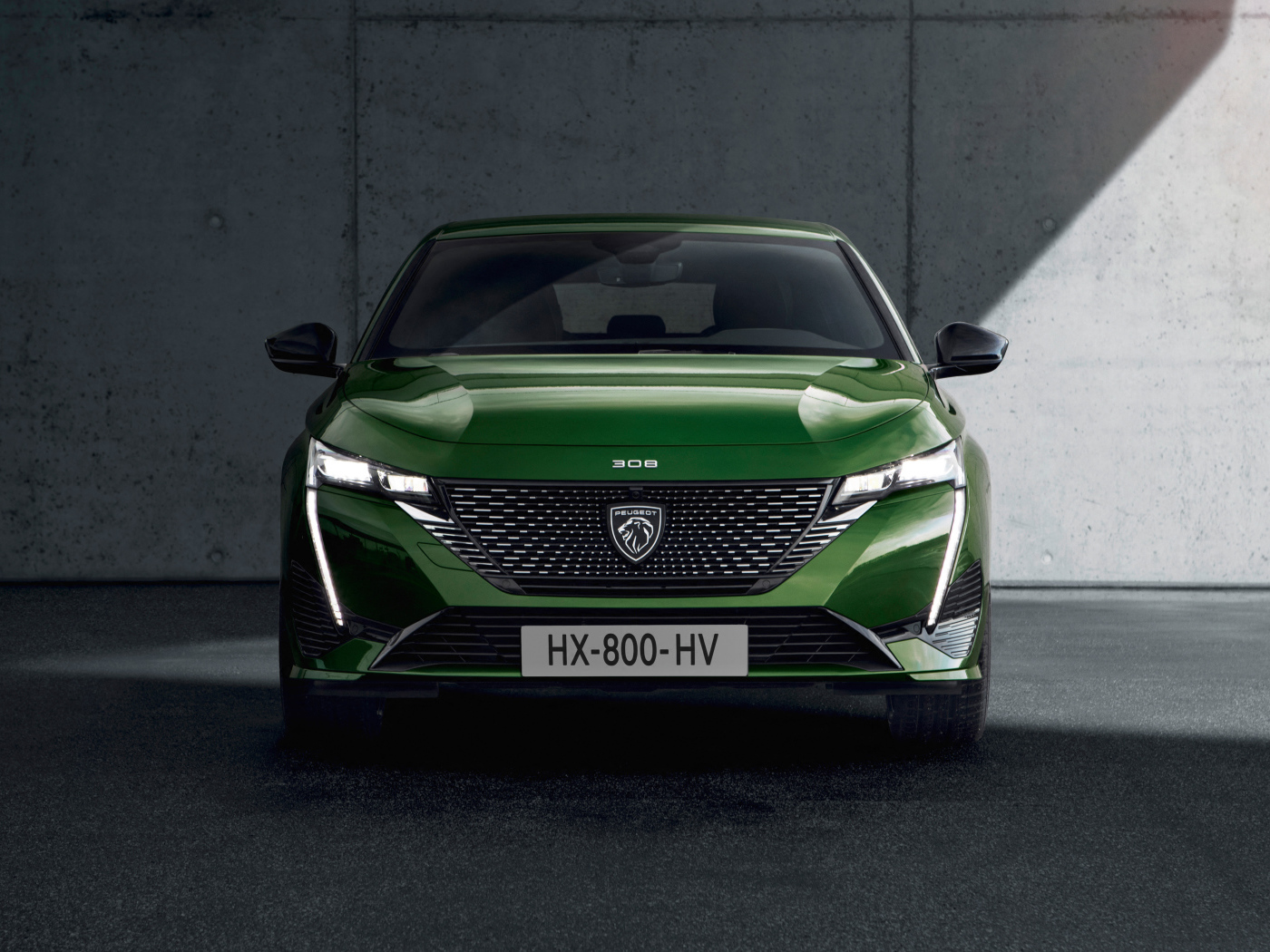 Автомобиль Peugeot 308, 2021 года вид спереди на фоне стены