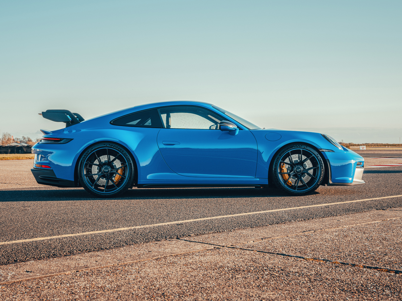 Голубой автомобиль Porsche 911 GT3 PDK 2021 года вид сбоку