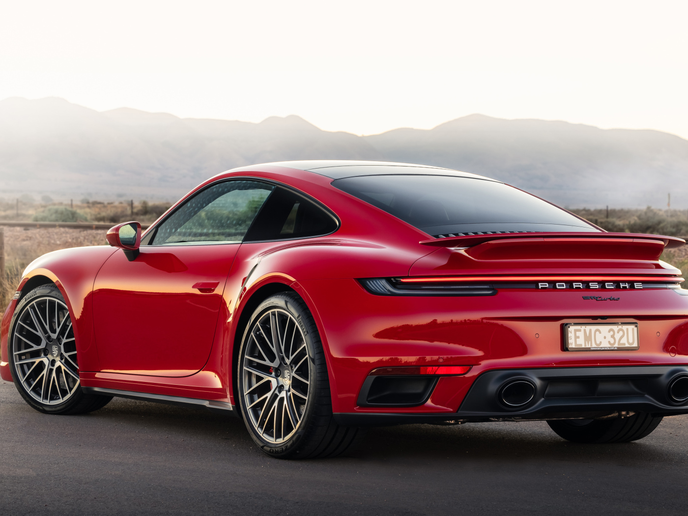 Красный автомобиль Porsche 911 Turbo 2021 года вид сзади