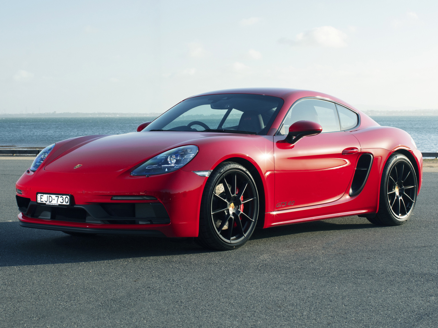 Красный автомобиль Porsche 718 Cayman GTS у моря