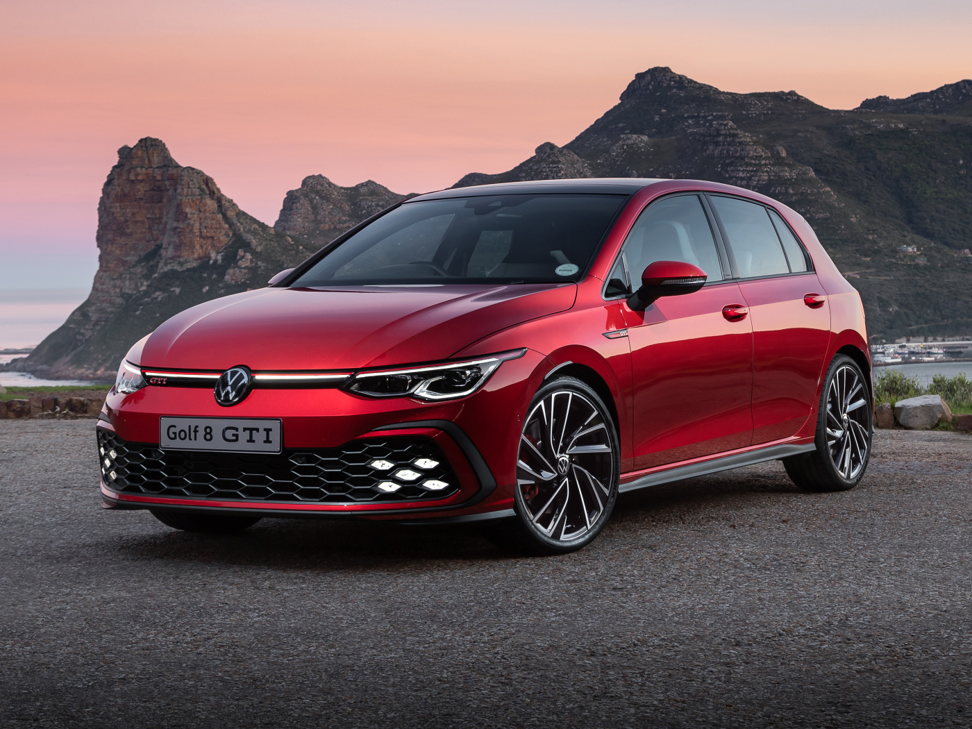 Красный Volkswagen Golf GTI 2021 года на фоне гор