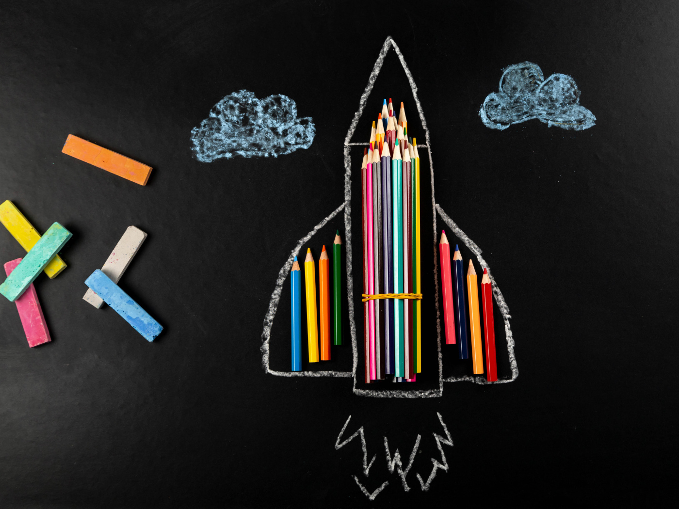 Нарисованная ракета с мелом и карандашами 