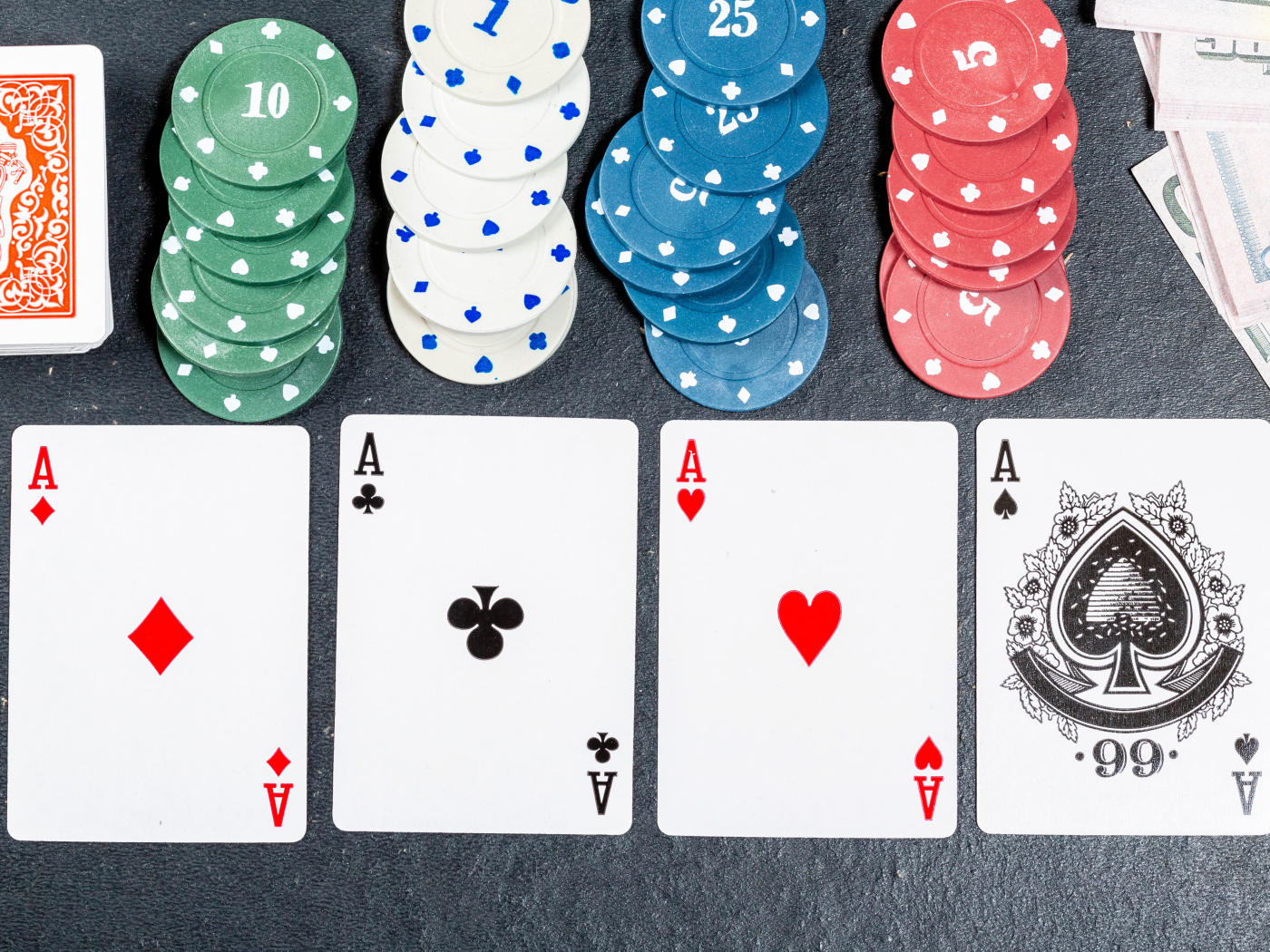Четыре туза с фишками на сером столе
