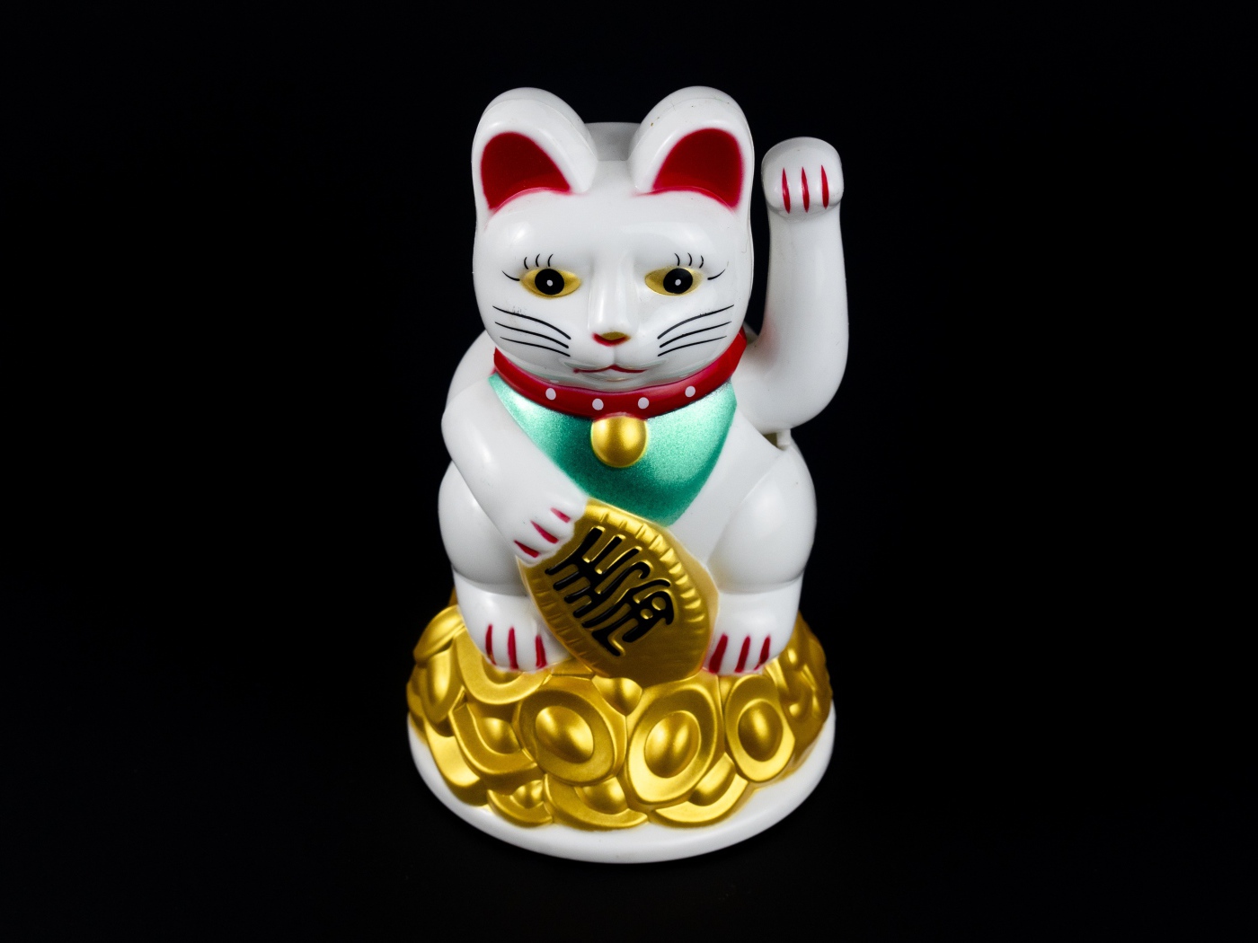 Японская фигурка манэки-нэко кошка на черном фоне