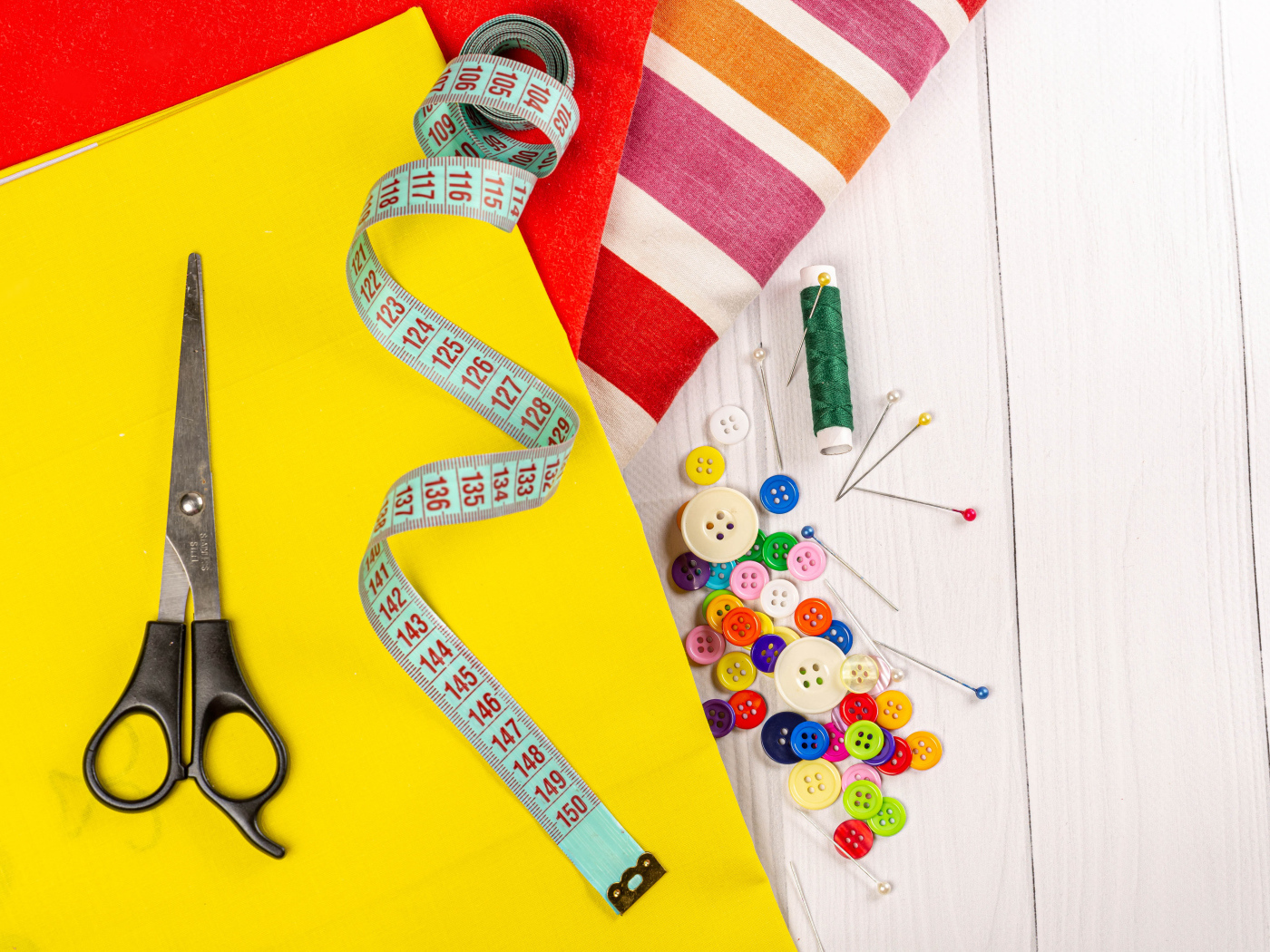 Разноцветная бумага и набор для шитья на столе 