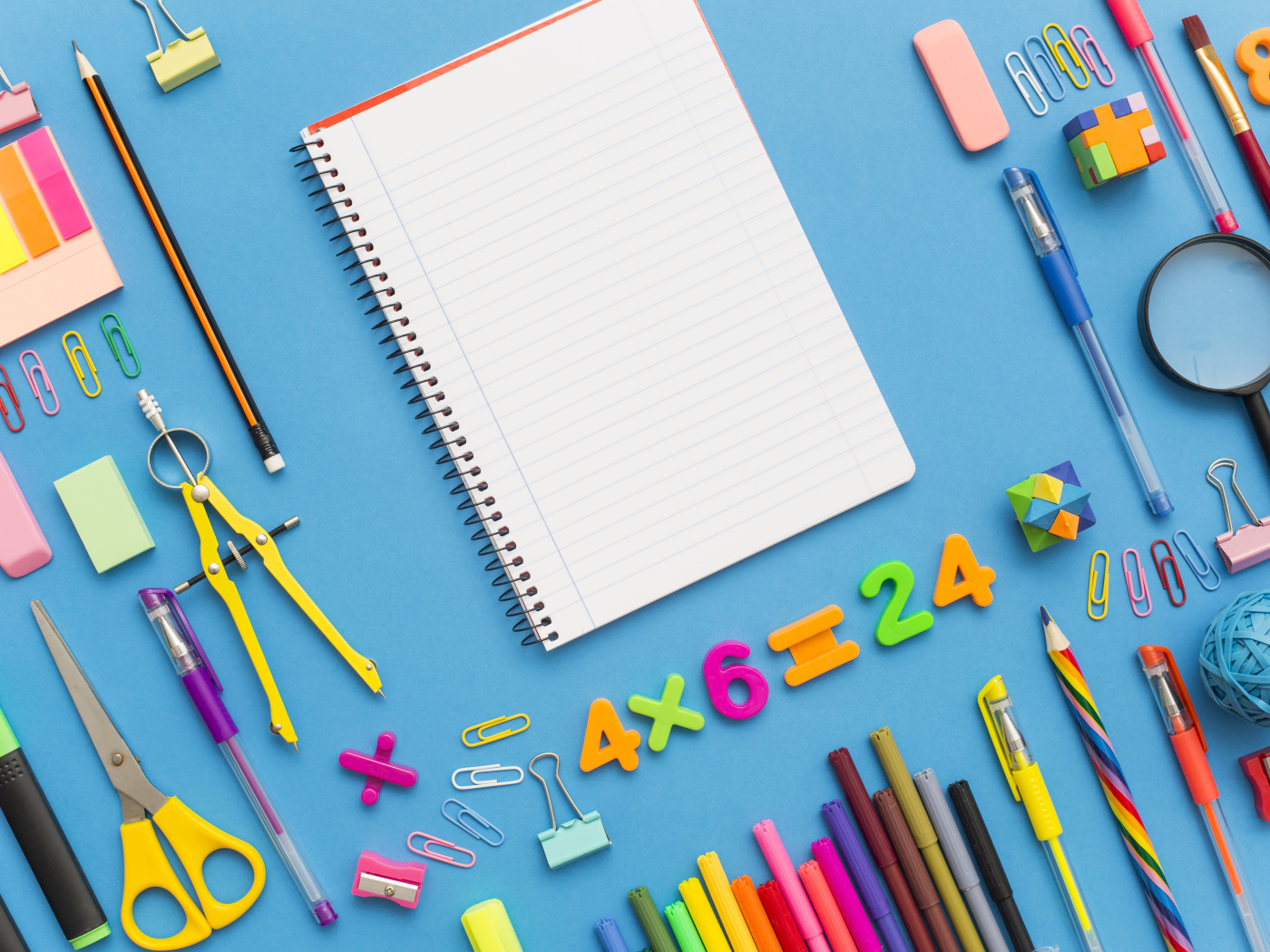 Тетрадь с канцелярскими предметами на голубом фоне 