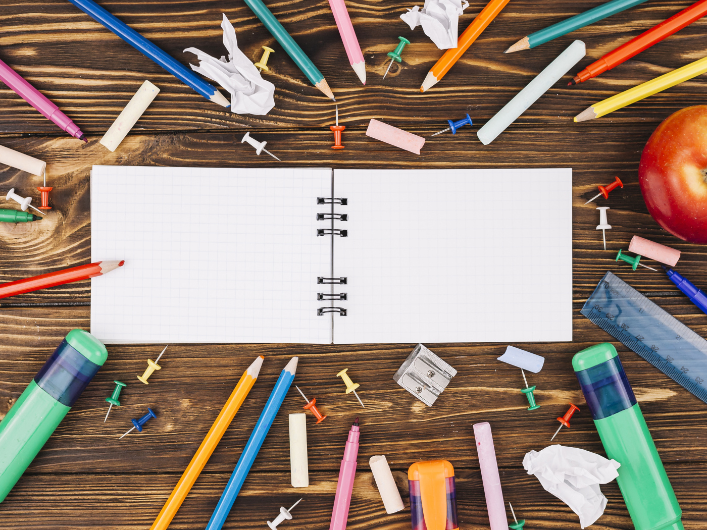 Открытый блокнот с ручками  на столе 