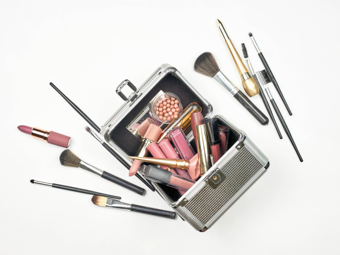 Набор косметики в чемодане на белом фоне