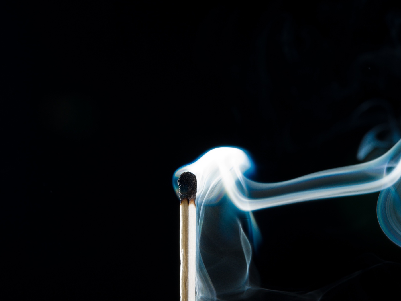 Белый дым от сожженной спички на черном фоне