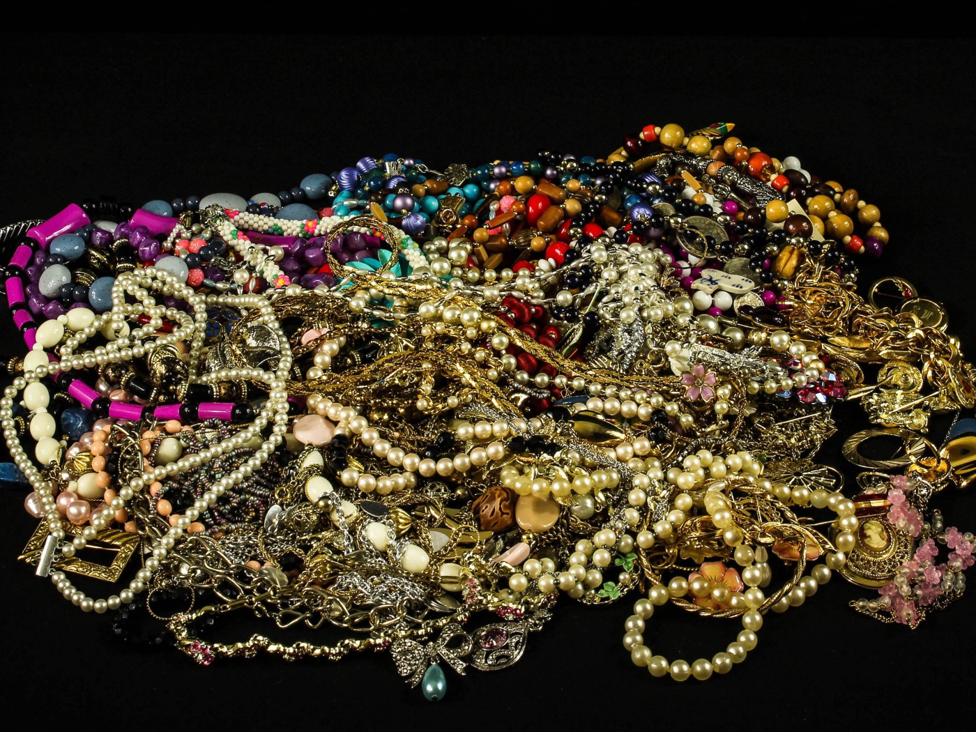 Много драгоценных ювелирных украшений на черном фоне