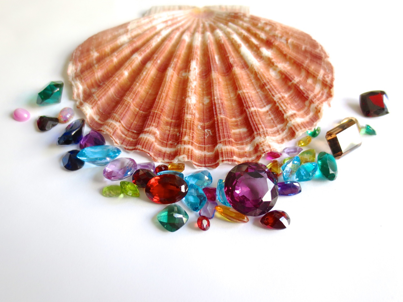 Ракушка и драгоценные камни на белом фоне