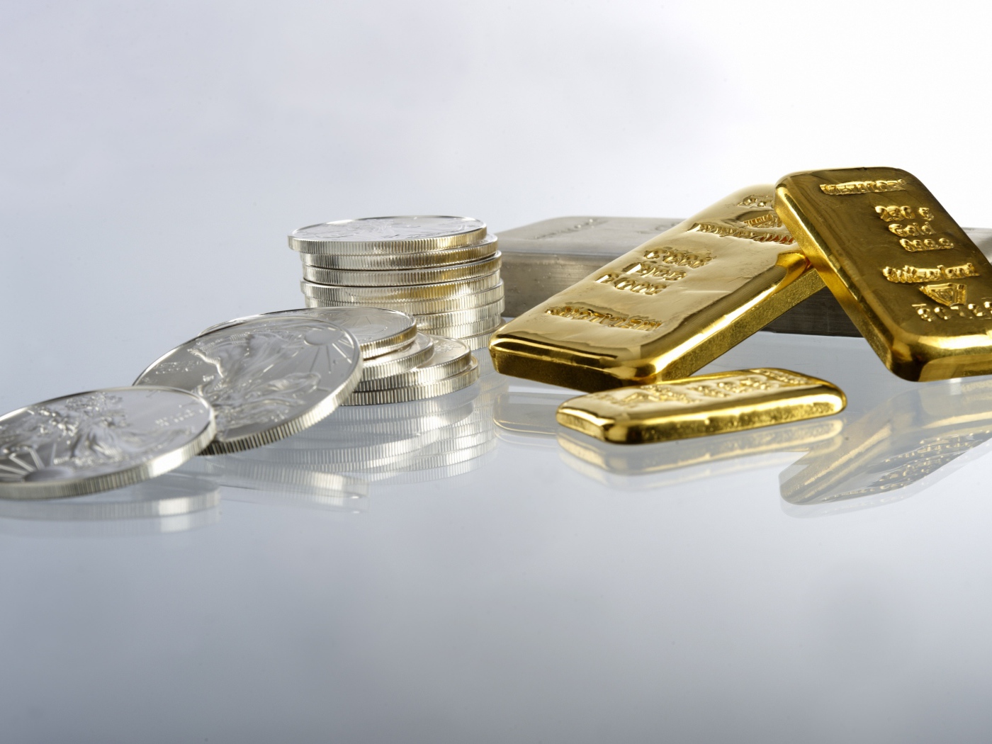 Gold bars of gold and coins on a white background