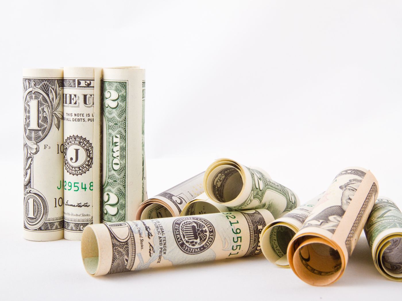 Скрученные в трубочки доллары на белом фоне 