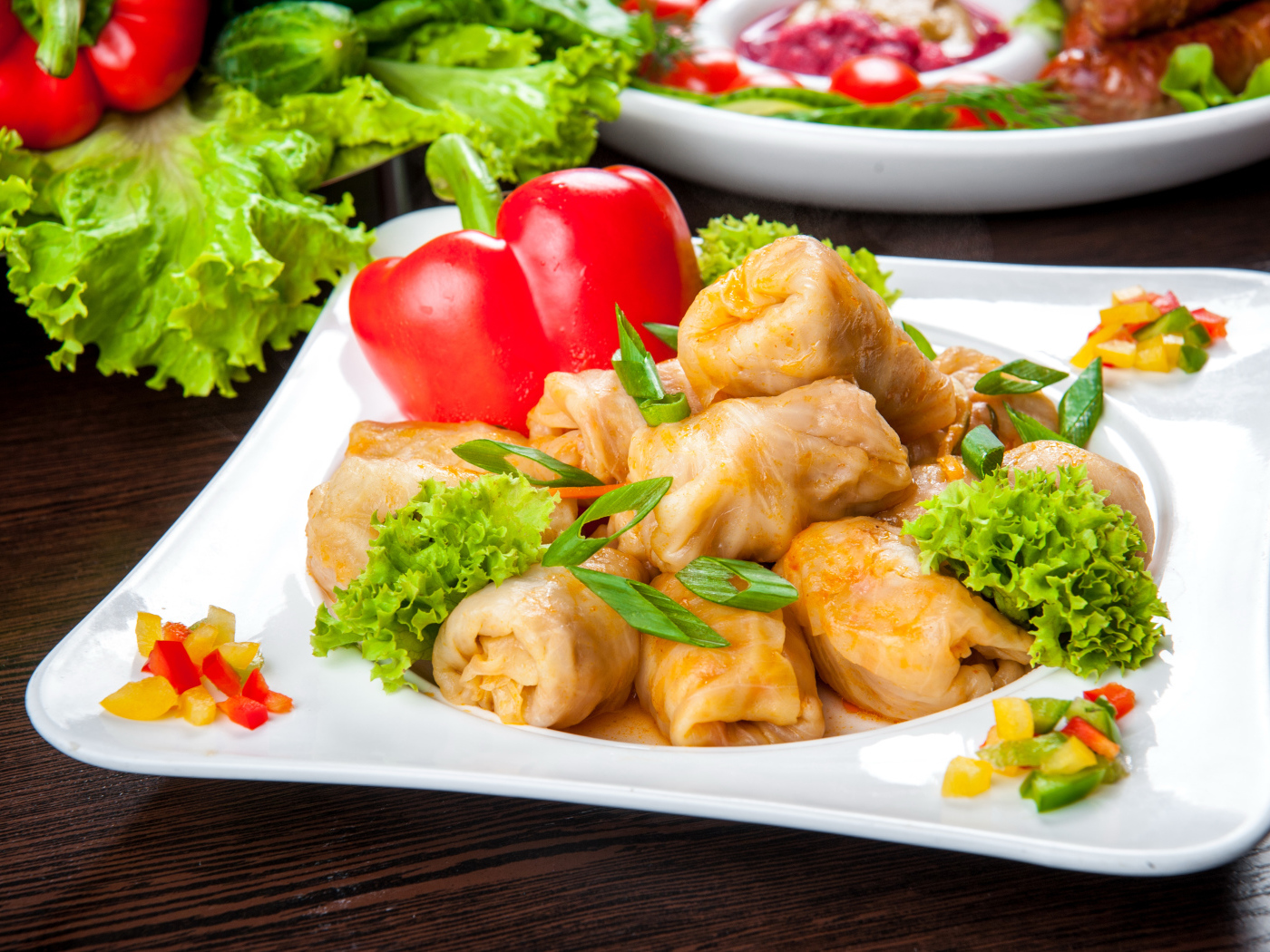 Аппетитные голубцы на тарелке с перцем 