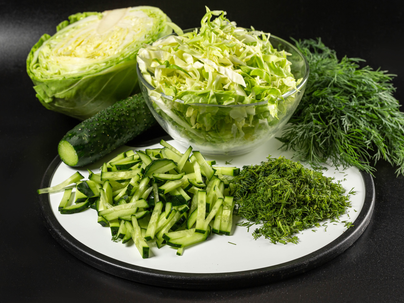 Салат с капусты на столе с огурцами и укропом 