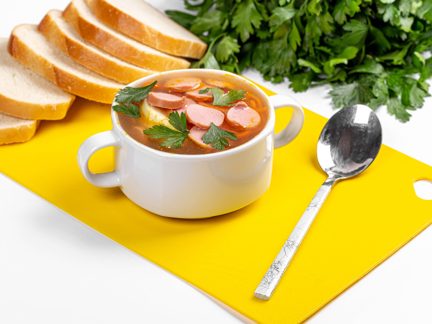 Вкусный суп солянка на столе с хлебом и петрушкой