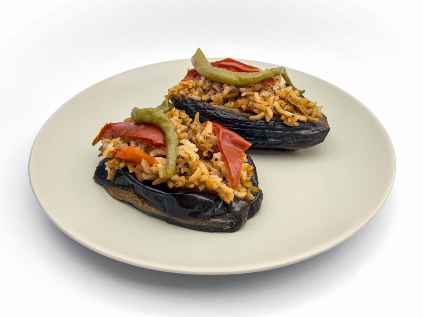 Блюдо из баклажанов с рисом на большой белой тарелке