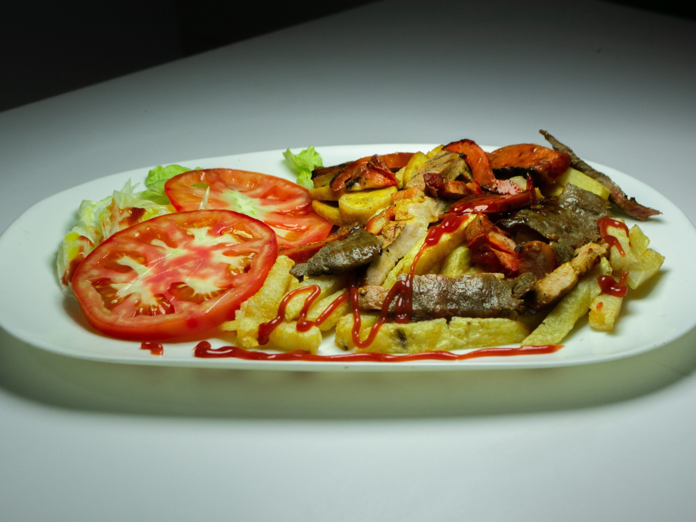 Картофель фри на тарелке с помидорами 