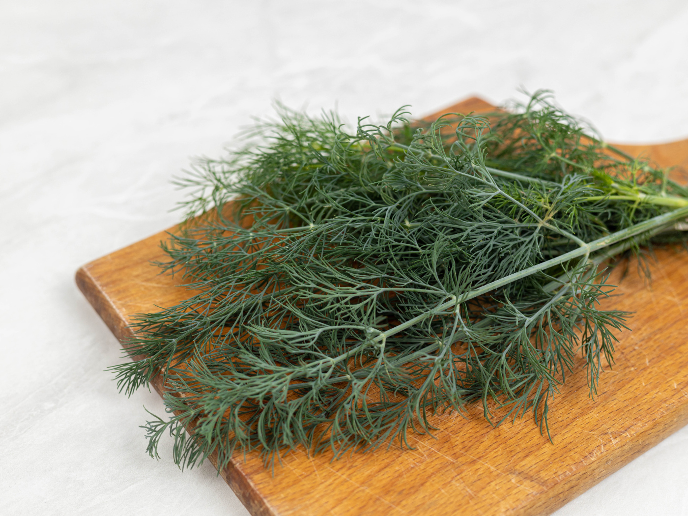 Свежий зеленый укроп на разделочной доске