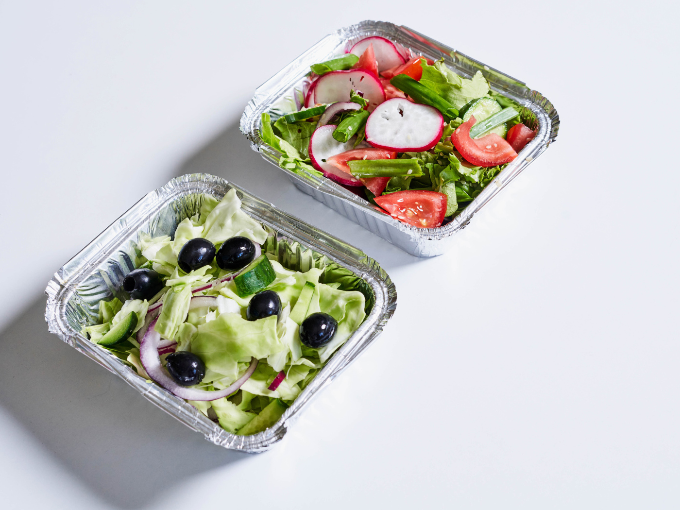 Салат из свежих овощей в тарелках на сером фоне 