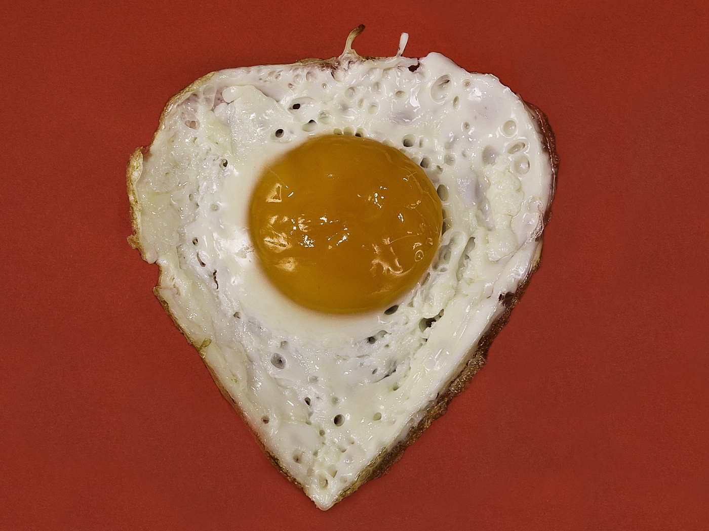 Яичница глазунья на красном фоне