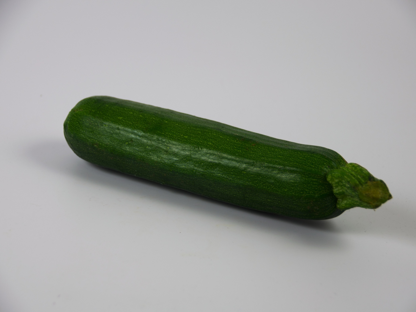 Зеленый кабачок на сером фоне