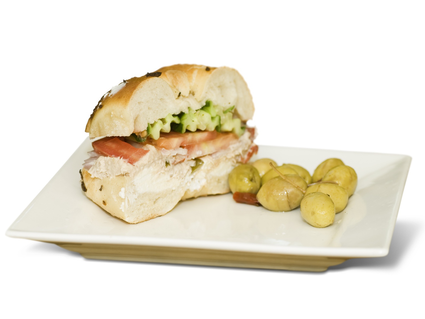 Половина гамбургера на тарелке с оливками