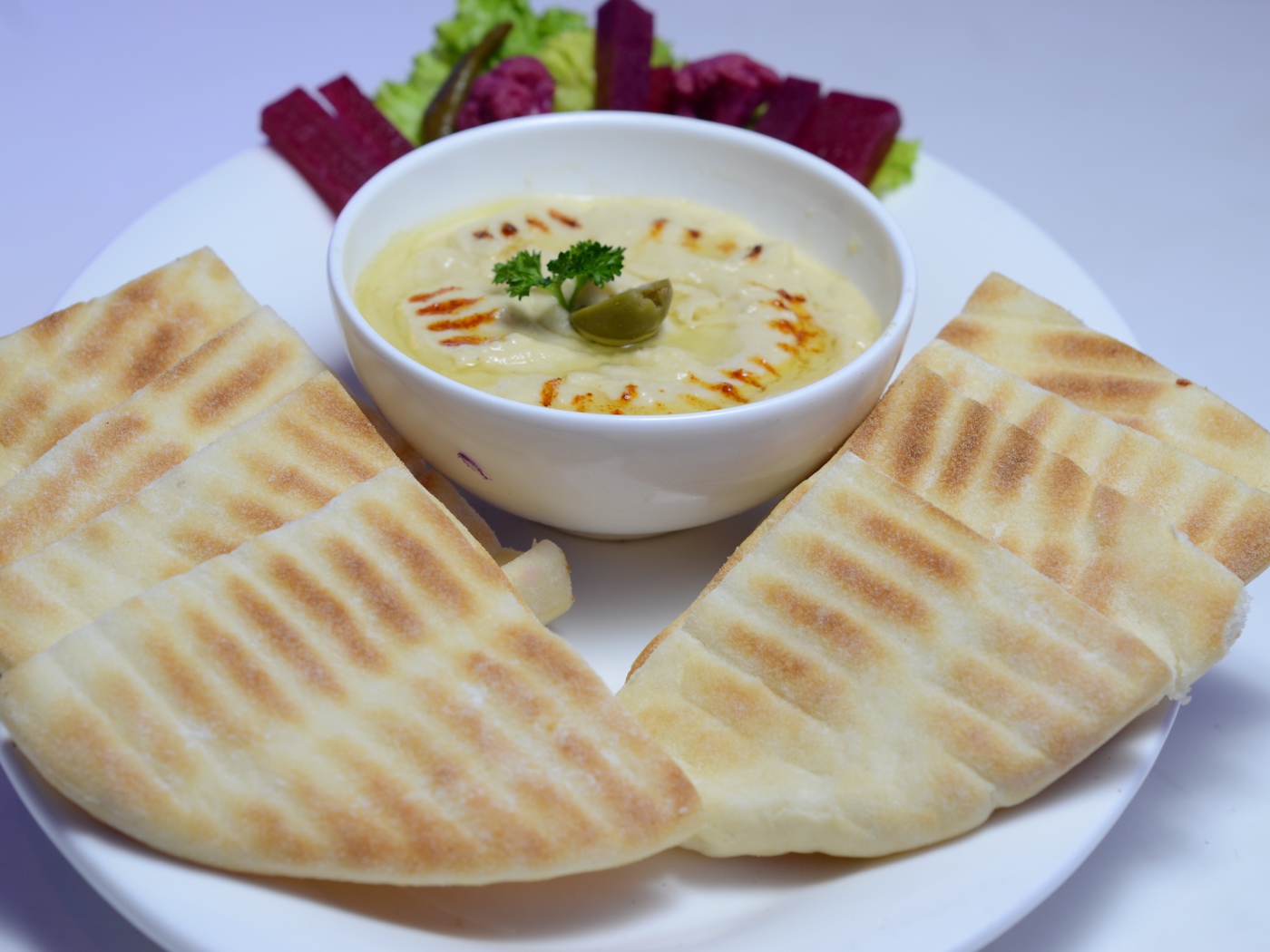 Хумус в белой тарелке с лавашом