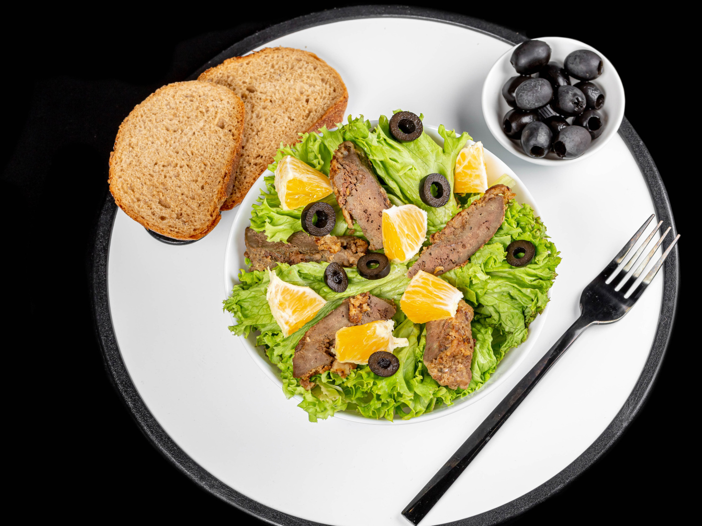 Листья салата с мясом на столе с хлебом