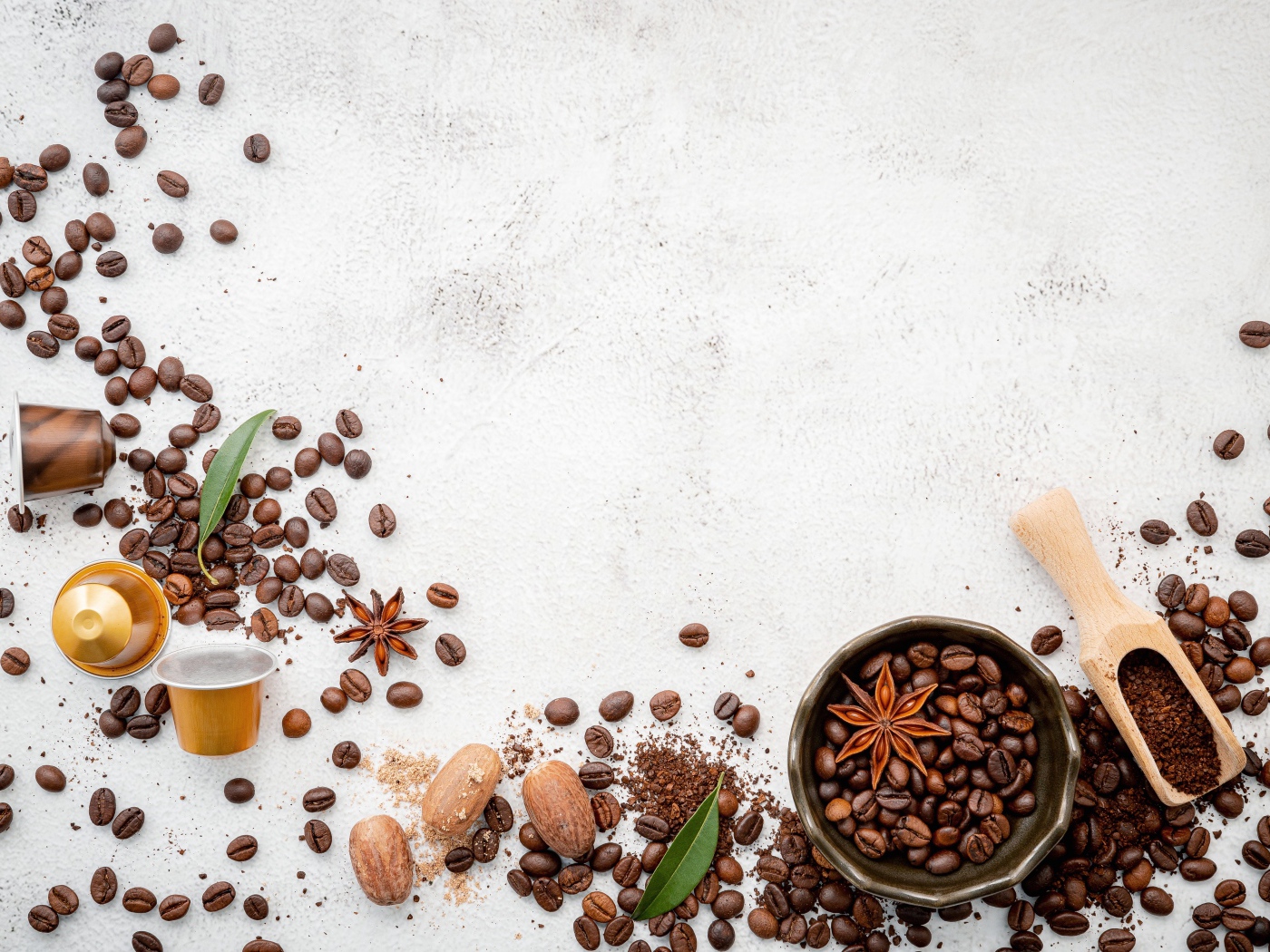 Кофейные зерна разбросаны по серому фону