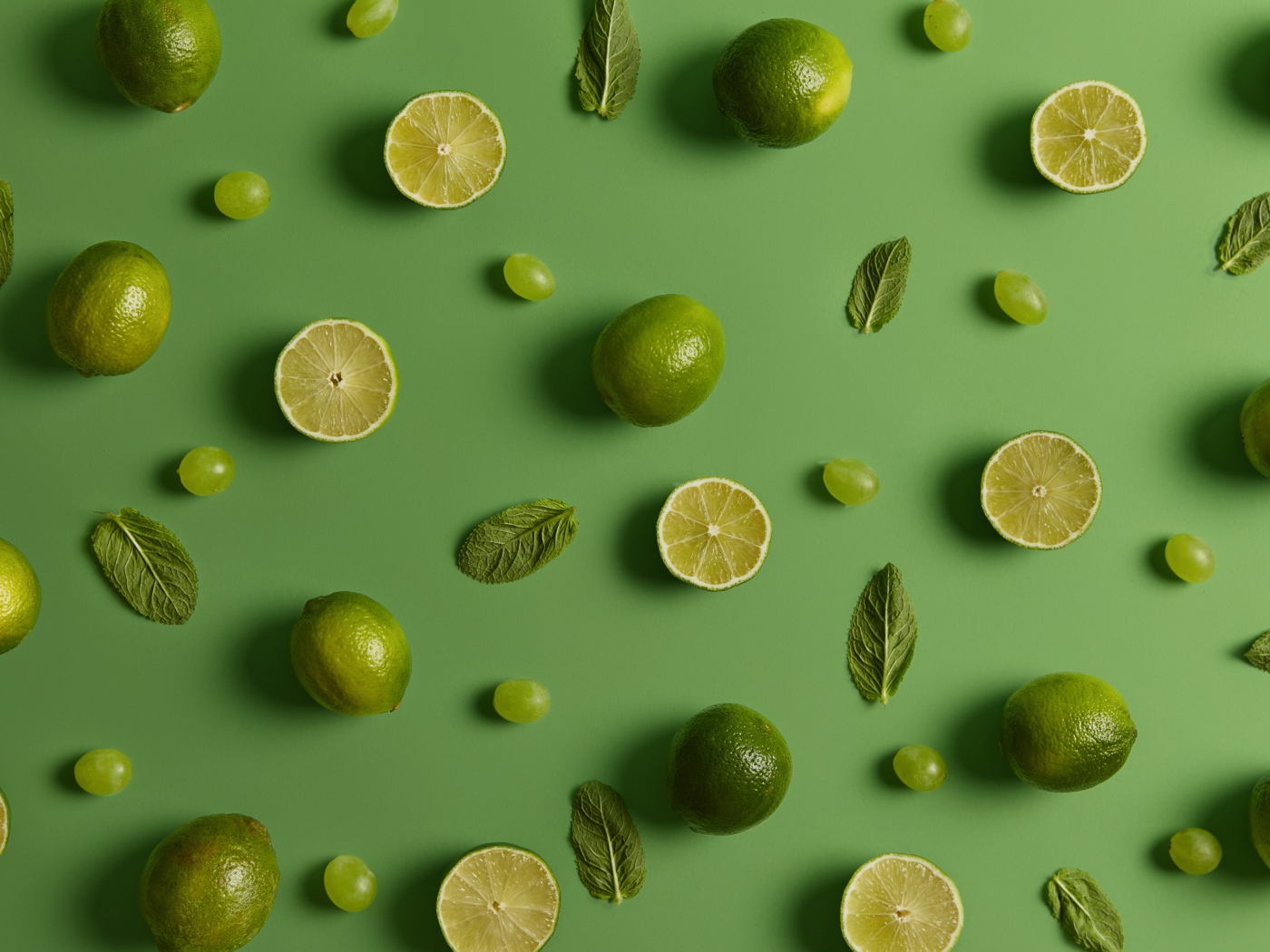 Лимоны и лаймы на зеленом фоне